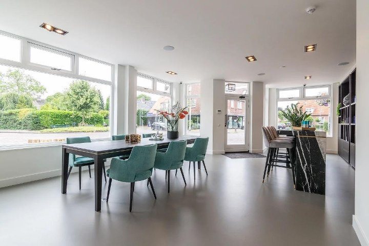 De salon met de mintgroene stoelen aan de lange tafel