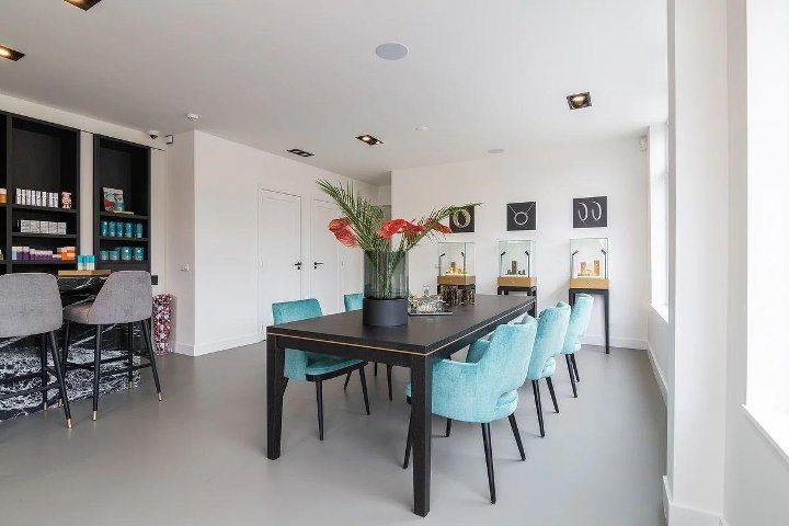 De tafel met de stoelen en de zwarte kasten